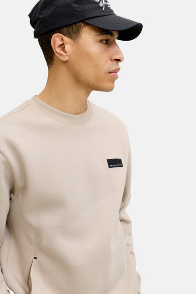 Beige sweatshirt van JACK & JONES, met een ronde hals en een logopatch op de borst.