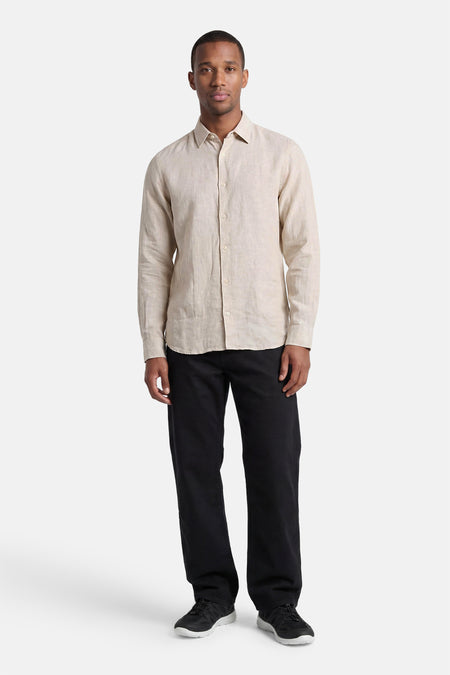 Chemise écru à manches longues de PREMIUM by JACK & JONES, portée par un homme avec un pantalon noir et des baskets.