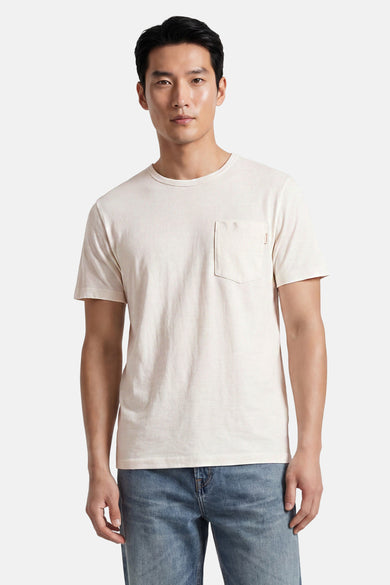 Off-white short-sleeve t-shirt with chest pocket, worn by model in front view, paired with blue jeans