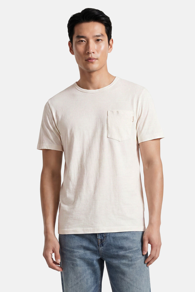 Off-white short-sleeve t-shirt with chest pocket, worn by model in front view, paired with blue jeans