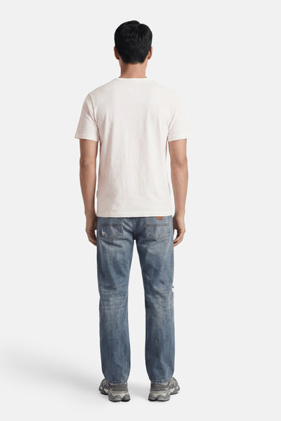 White short-sleeve t-shirt back view, plain cotton, worn with distressed blue jeans and chunky sneakers