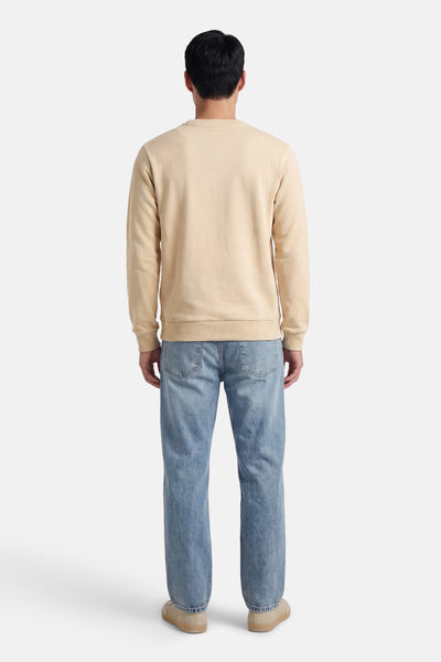 Beige JACK & JONES sweatshirt, achterkant, gedragen met een lichtblauwe jeans en beige schoenen.