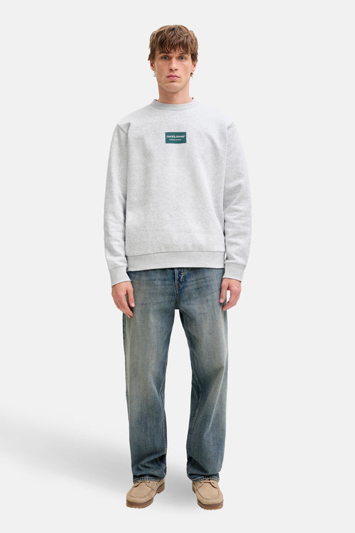 Gemêleerd grijs sweatshirt van JACK & JONES, met vierkant logo op de voorkant, gedragen met een blauwe jeans en bootschoenen.