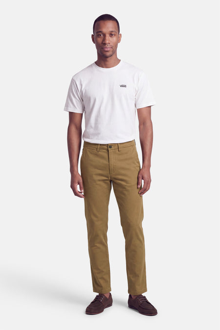 Homme portant un chino beige JACK & JONES avec un t-shirt blanc et des baskets marron.