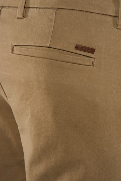 Zoom sur la poche arrière d’un chino beige JACK & JONES avec étiquette en cuir marron.