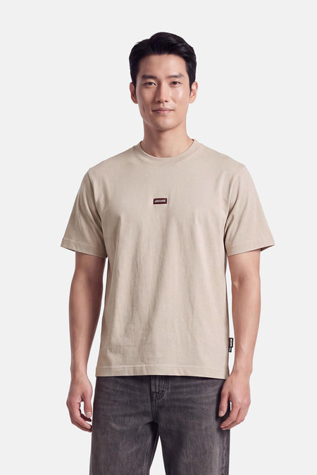 T-shirt à manches courtes écru JACK & JONES porté par un mannequin, avec logo sur la poitrine.
