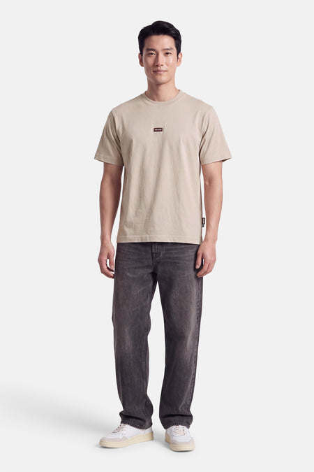 JACK & JONES T-shirt à manches courtes écru porté avec un jean gris et des baskets blanches