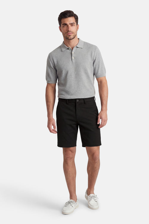 Short noir de JACK & JONES JEANS INTELLIGENCE, porté avec un polo gris et des chaussures bateau blanches.