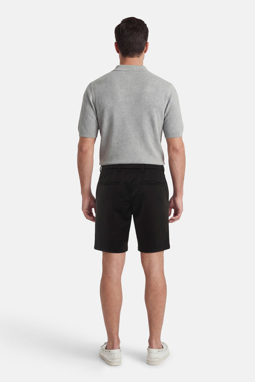 Short noir par JACK & JONES JEANS INTELLIGENCE, porté avec une chemise grise et des chaussures bateau crème, vue de dos.