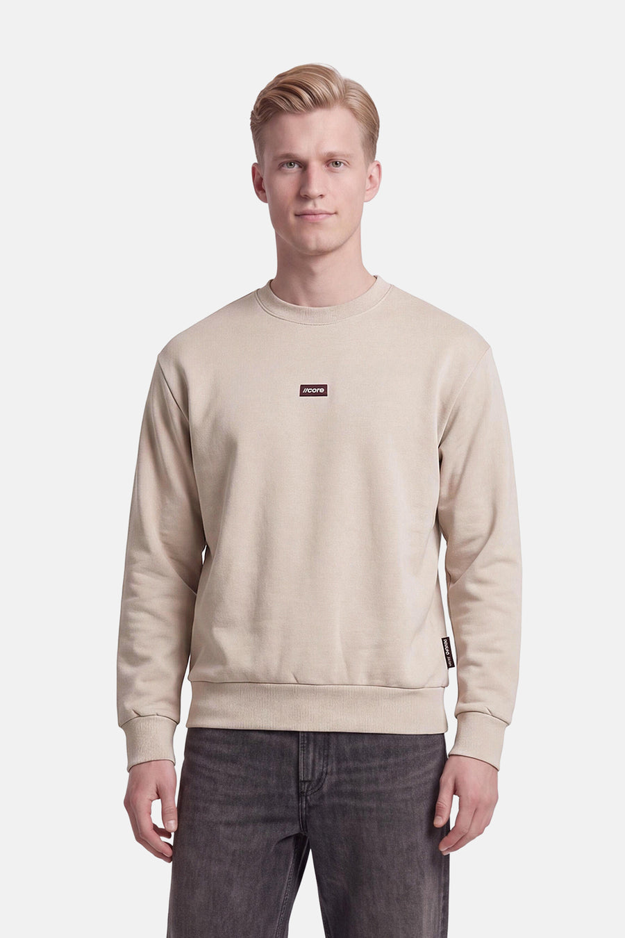 Sweat col rond écru JACK & JONES porté par un mannequin, avec logo sur la poitrine.