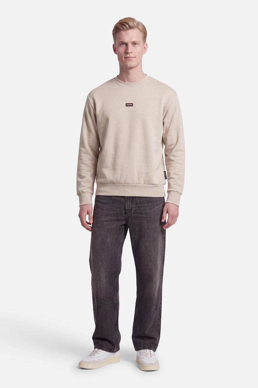 Sweat col rond écru JACK & JONES porté par un mannequin, avec petit logo sur la poitrine.