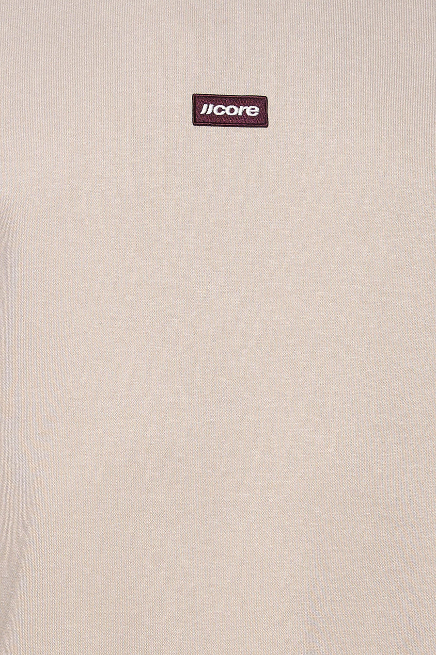 Détail du sweat col rond écru JACK & JONES avec écusson « JCORE ».
