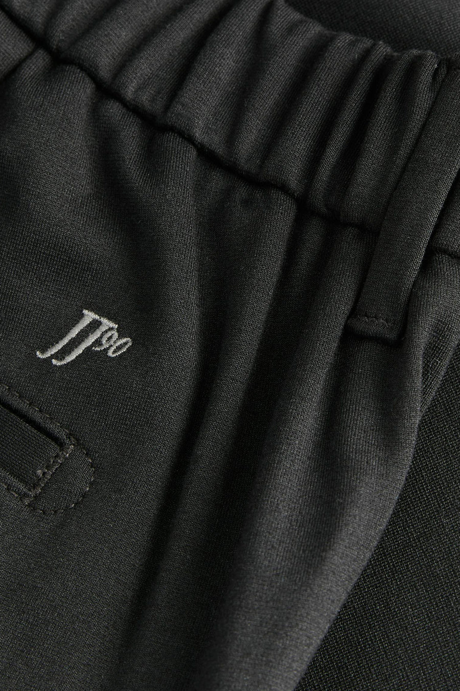 Chino noir de PREMIUM by JACK & JONES, détail de la taille élastique et du logo brodé.