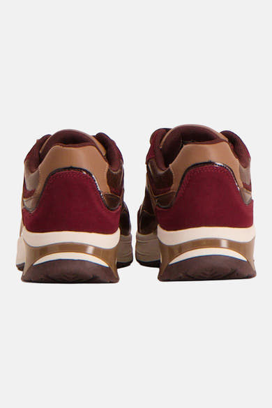 Burgundy suede and tan leather sneakers from back view, featuring white midsole and translucent heel accent