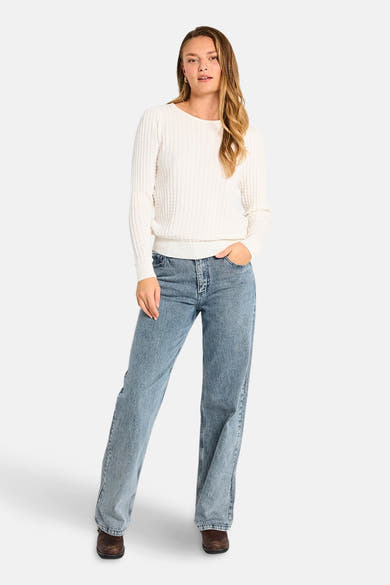 Pull blanc à col rond de FREEQUENT, en tricot texturé, porté avec un jean bleu et des chaussures marron.
