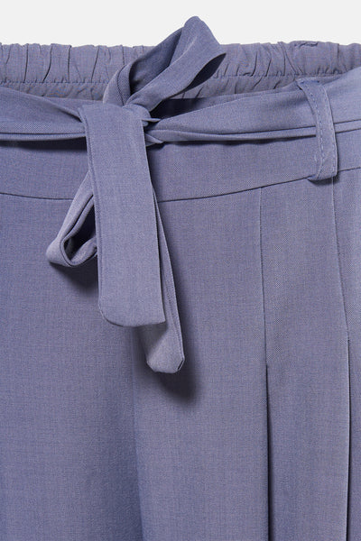 Pantalon costume bleu par Terra di Siena, avec ceinture nouée et plis verticaux.
