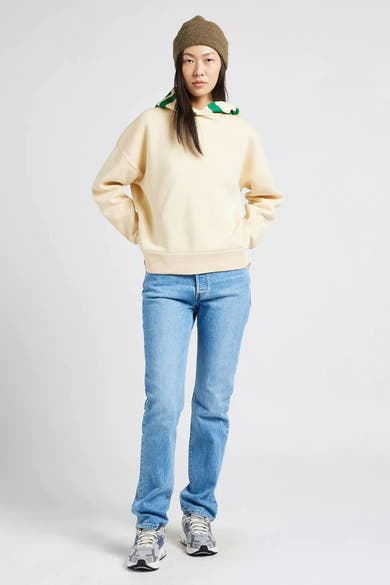 Lichtblauwe rechte jeans van Levi's®, gedragen met een crèmekleurige trui en een olijfgroene muts.