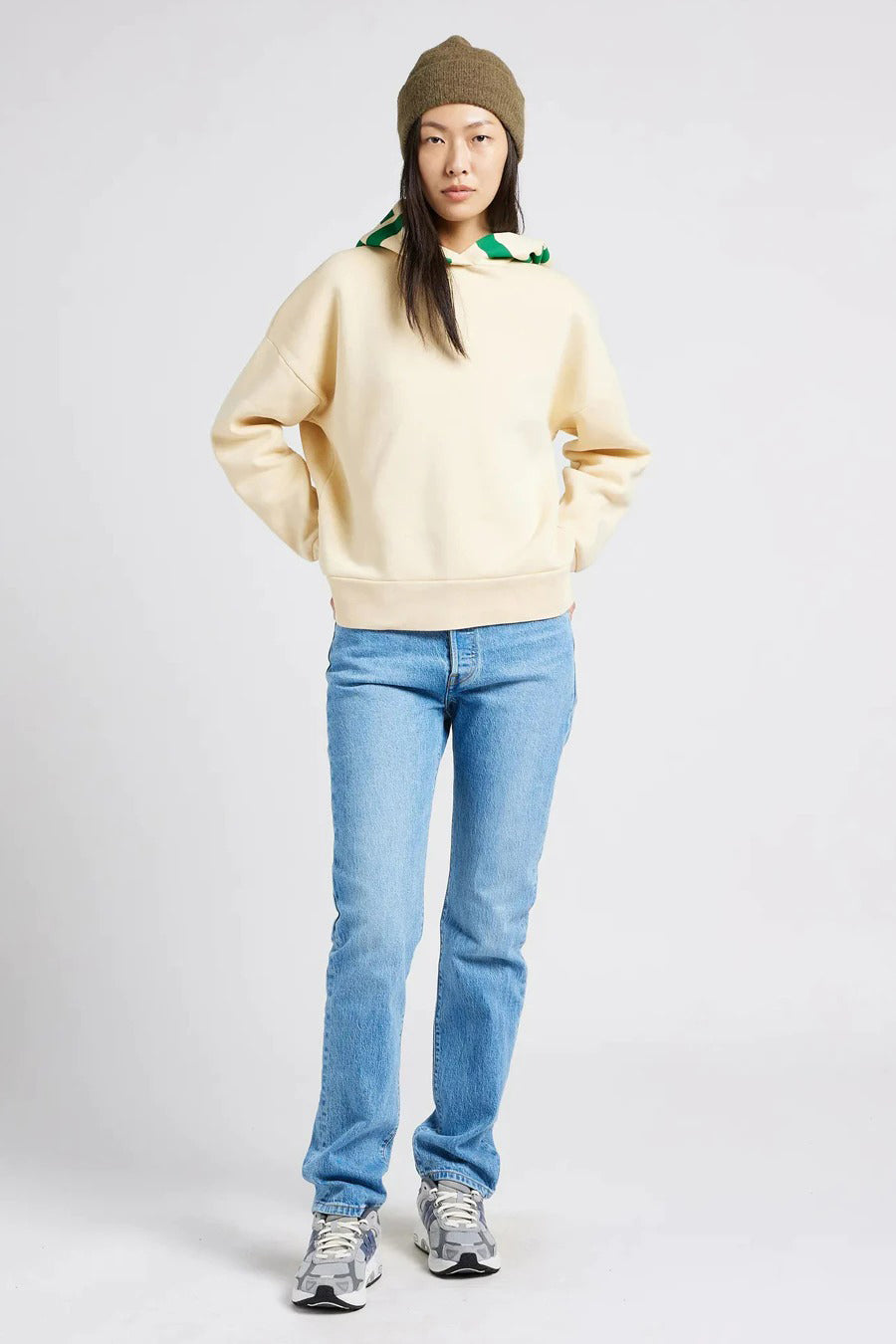 Lichtblauwe rechte jeans van Levi's®, gedragen met een crèmekleurige trui en een olijfgroene muts.