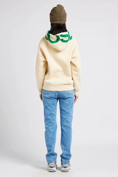 Rechte lichtblauwe spijkerbroek van Levi's®, gedragen met een beige hoodie en een kaki muts.