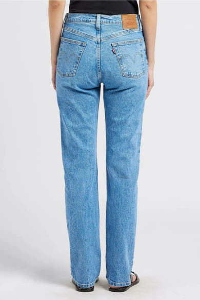 Rechte lichtblauwe spijkerbroek van Levi's, achterkant, met leren etiket en rode patch.