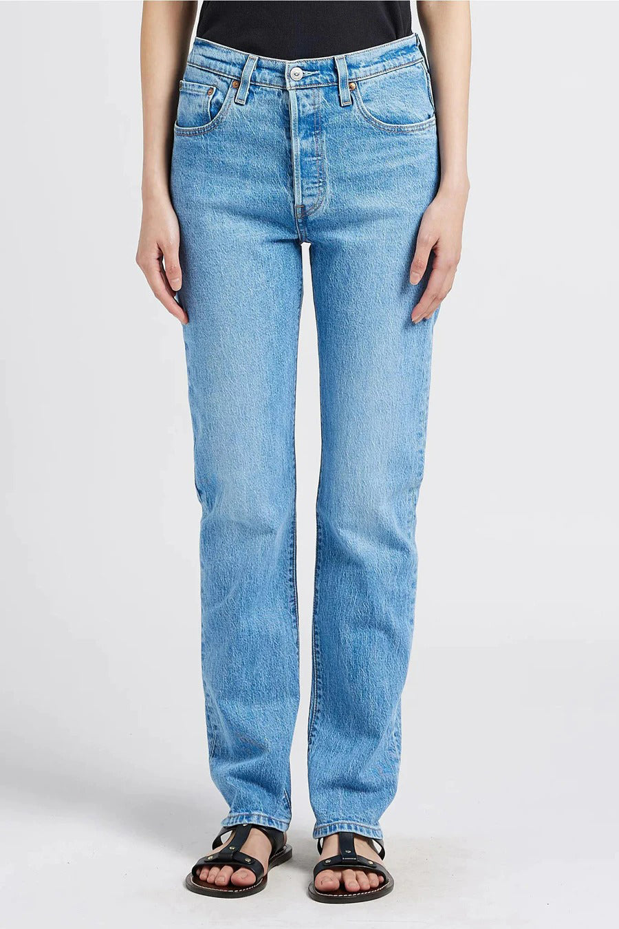 Rechte spijkerbroek van lichtblauw denim van Levi's®, met een rechte pasvorm en zwarte leren sandalen.