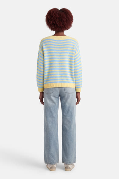 Multicolore ronde hals trui van Terra di Siena, blauwe en gele strepen, gedragen met een lichtblauwe jeans.