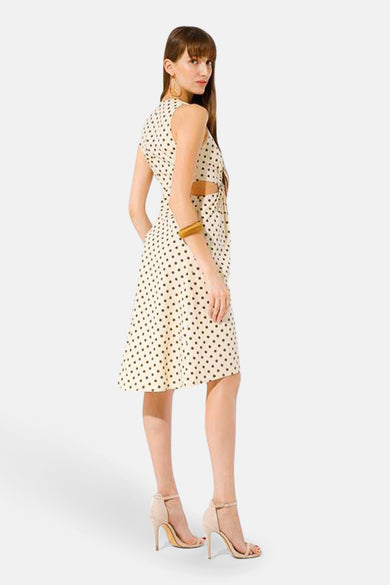 Beige GOA GOA jurk met zwarte stippen, met uitsnede in de taille en gouden accessoires.