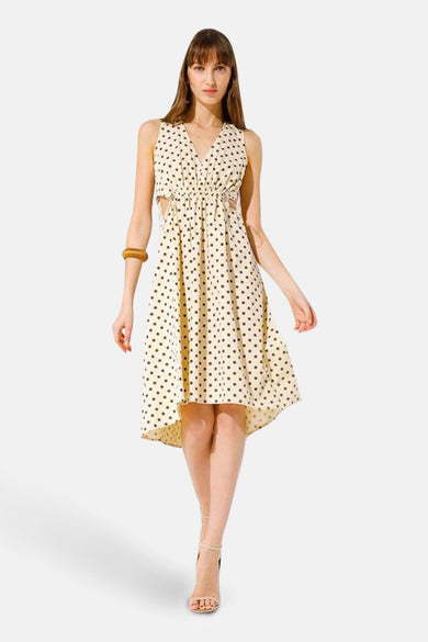 Beige stippelde jurk van GOA GOA, asymmetrische snit, met zijdelingse uitsnijdingen en houten bandje.
