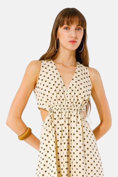 Beige jurk met bruine stippen van GOA GOA, met uitsnijdingen aan de taille en gouden accessoires.