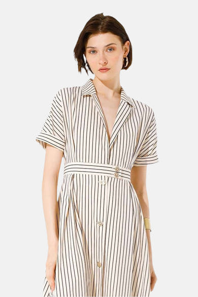 Robe longue beige de GOA GOA à rayures verticales noires, avec ceinture à la taille et boutons dorés.
