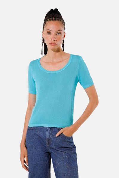 Pull à col rond turquoise de Goa Goa, porté avec un jean pailleté bleu foncé.