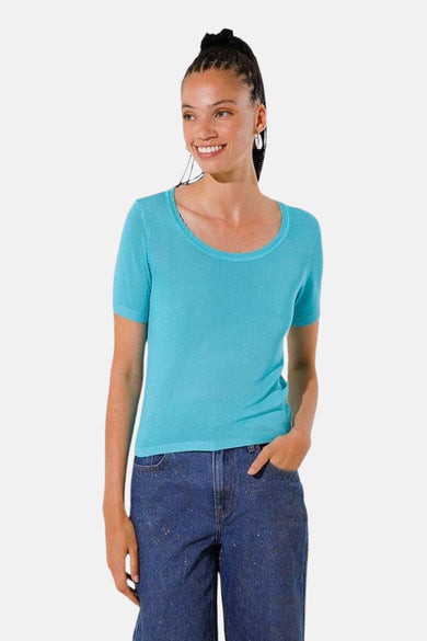 Pull turquoise à col rond de GOA GOA, porté avec un jean ample et orné de petites paillettes.