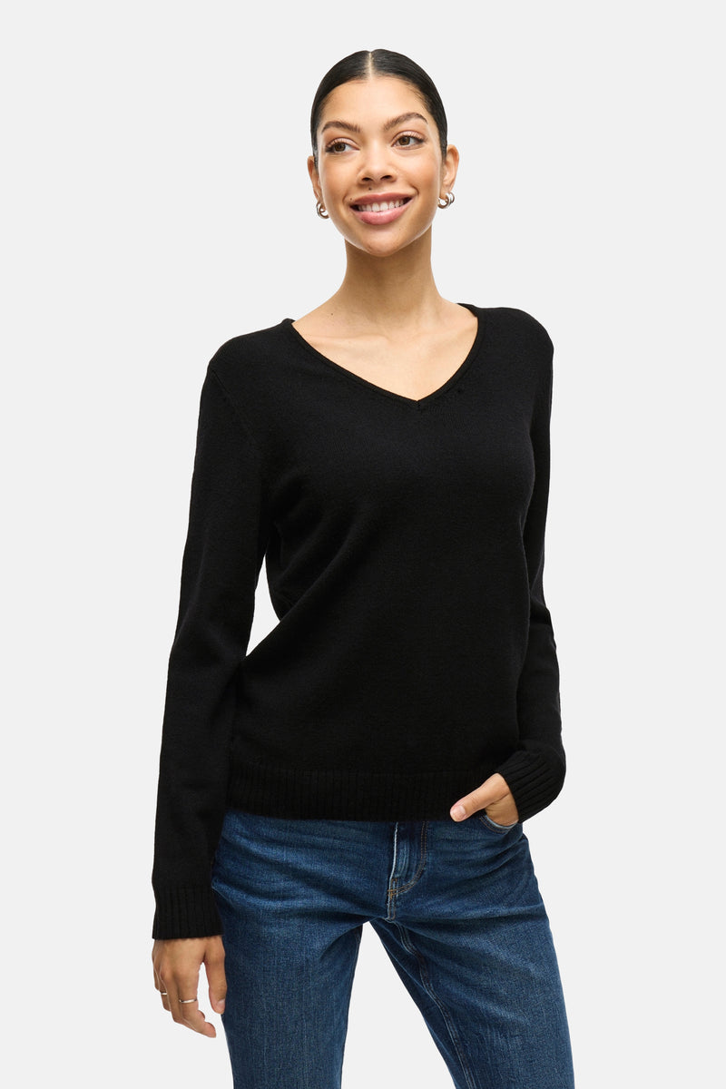 Pull noir by VILA, porté avec un jean, avec des boucles d'oreilles argentées.