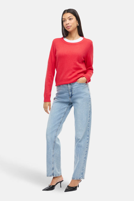 Pull à col rond rouge de VILA®, porté avec un jean bleu clair et des mules à talons noirs.