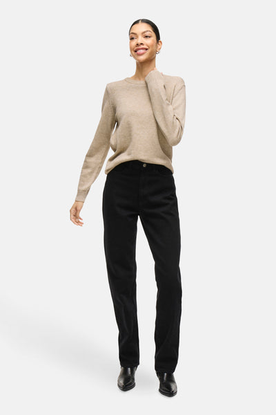 Pull beige de VILA®, porté avec un jean noir et des bottes en cuir.