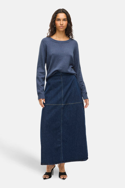 Ronde hals trui blauw van VILA®, gedragen met een lange donkerblauwe spijkerrok en zwarte naaldhakken.