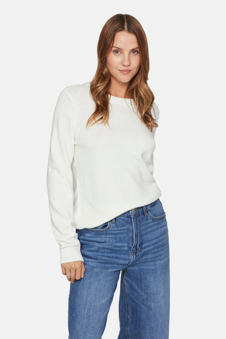 Pull col O blanc de VILA®, porté avec un jean bleu ample.