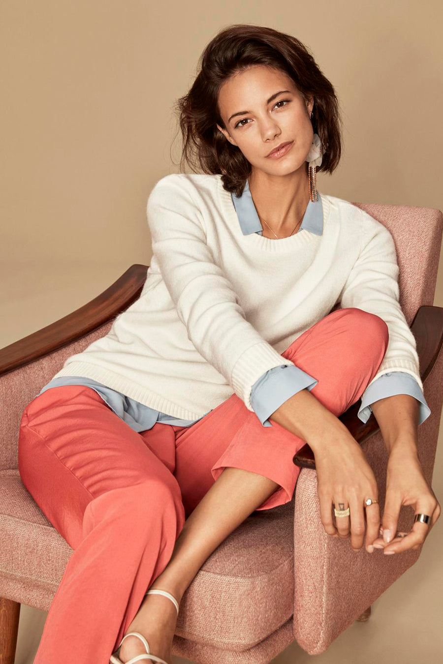 Pull col rond blanc de VILA®, porté sur une chemise bleu clair et avec un pantalon corail.