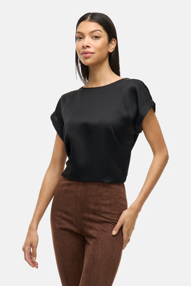 Top uni noir à manches courtes de VILA, porté avec un pantalon marron.
