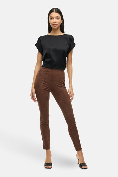 Top uni noir à manches courtes par VILA®, porté avec un pantalon marron moulant et des talons hauts.