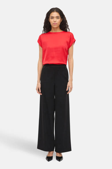 T-shirt rouge à manches courtes de VILA®, porté avec un pantalon noir à jambes larges.