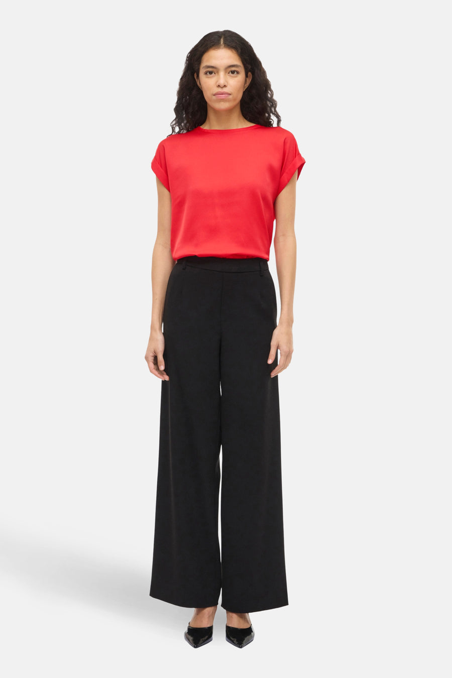 T-shirt rouge à manches courtes de VILA®, porté avec un pantalon noir à jambes larges.