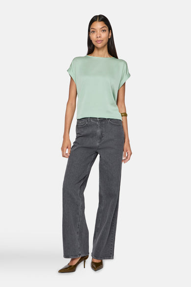 Groen T-shirt met korte mouwen van VILA, gedragen met een grijze straight-leg jeans en bruine pumps.