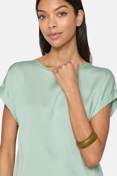Groen T-shirt met korte mouwen van VILA®, gedragen met een olijfgroene armband.