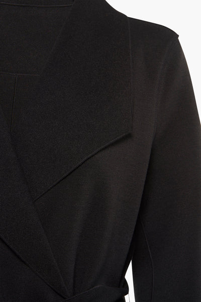 Veste longue noire de VILA, montrant les détails du col et la texture tricotée.
