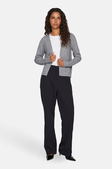 Grijze cardigan van VILA®, gedragen over een wit T-shirt en een wijde zwarte broek met pumps.