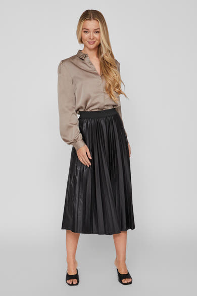 Zwarte geplooide midi-rok van VILA®, gedragen met een taupekleurige satijnen blouse en zwarte muiltjes.