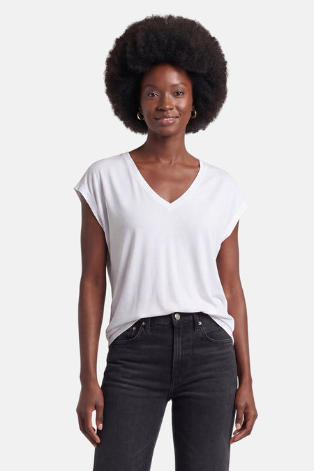 T-shirt blanc uni à col en V et manches courtes de VILA®, porté par une femme avec un jean noir.