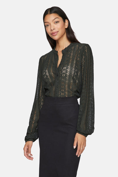 Chemisier vert à manches longues de VILA®, en dentelle florale transparente, porté avec une jupe noire.