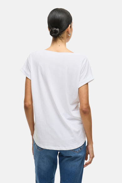 Wit top van VILA®, gedragen met een blauwe jeans, achtergezicht, kapsel knot.